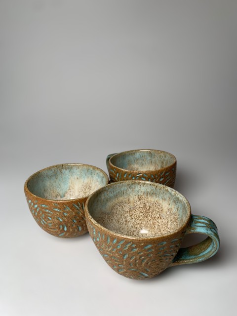 Taza mediana pasta café expuesta con esgrafiado celeste brillante. Interior blanco/celeste